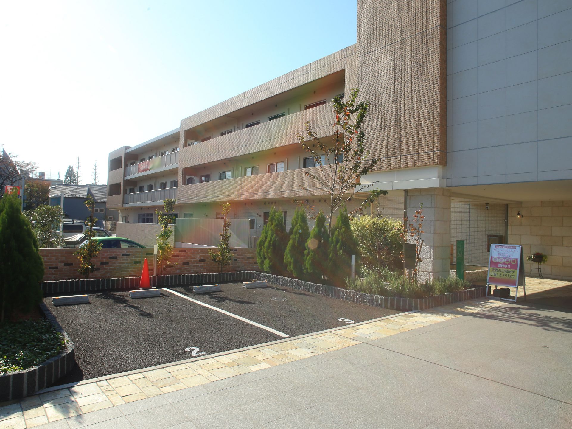 施設は、鉄筋コンクリート造３階建てである。ベージュ色を基調とした外観で周囲には植物が植えられている。駐車場を完備している。