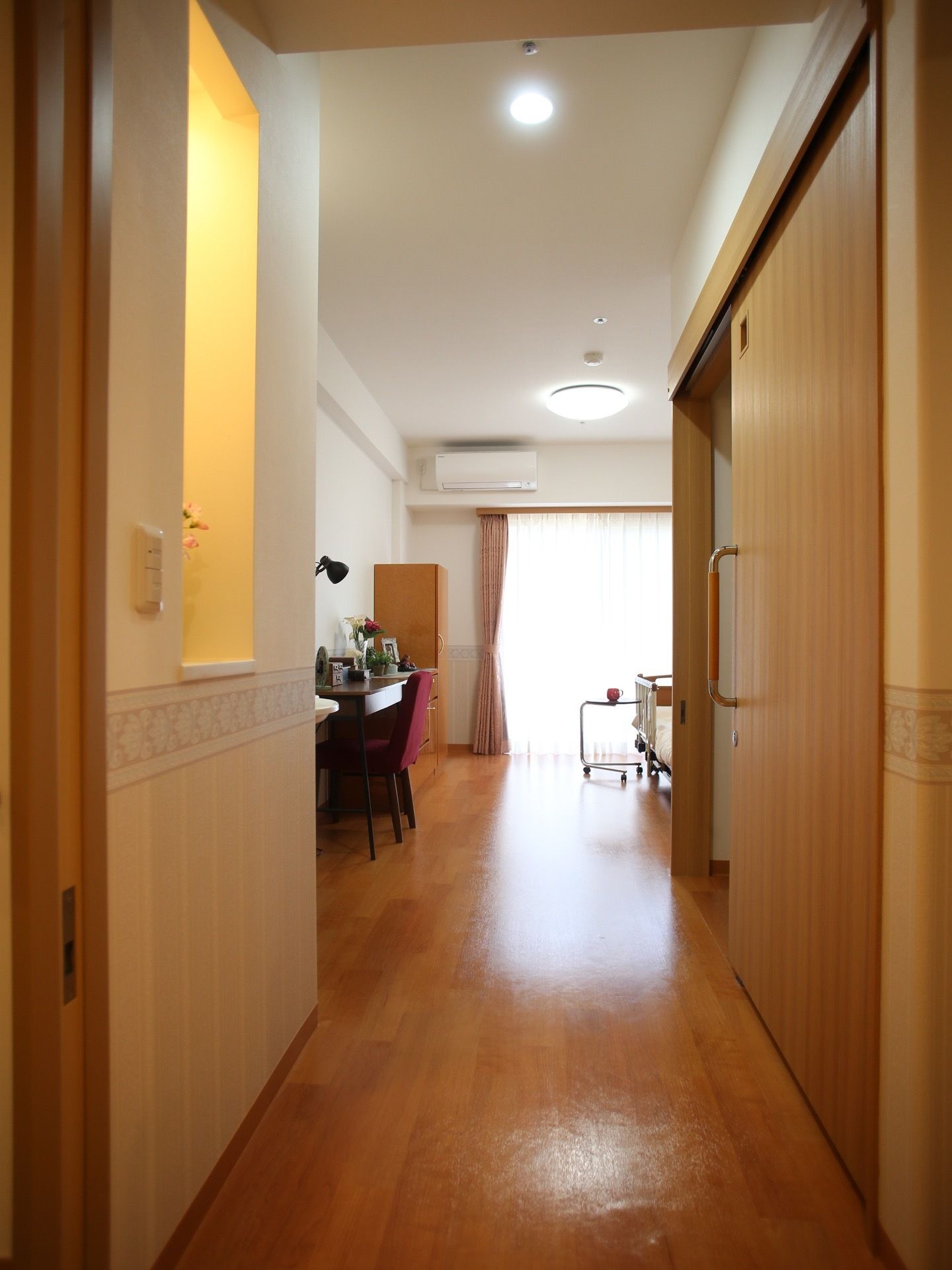 居室に入って左手には、花瓶などを飾ることができるスペースがある。右手はトイレで、スライド式のドアが取り付けられている。