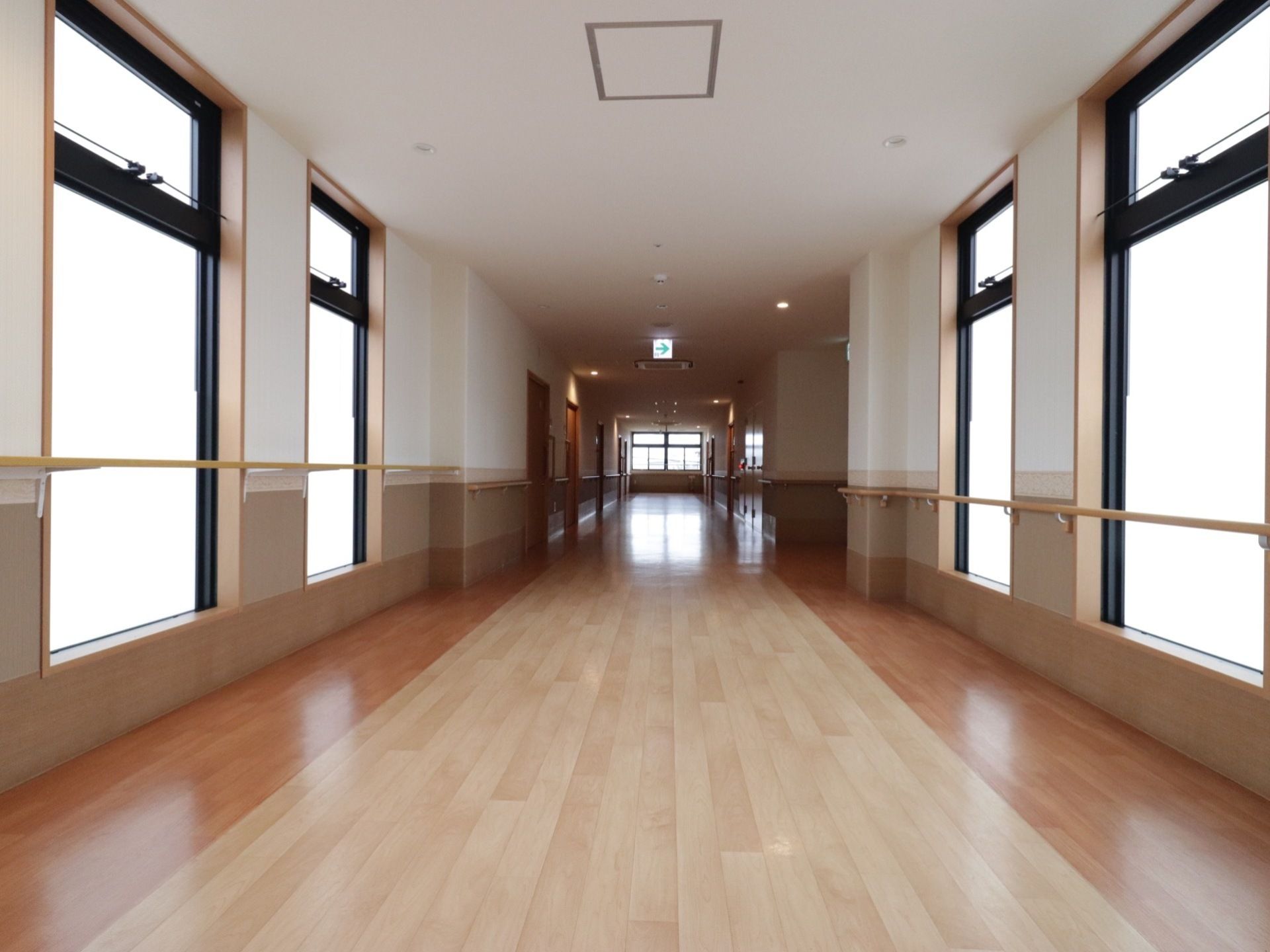 非常に広い幅をとり、壁面には手すりを設置した木調の廊下