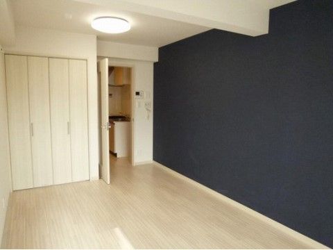 全体的に白を基調とした内装だが、右側の壁は黒い壁紙になっている。クローゼットがあり、ドアの向こうにキッチンがある。