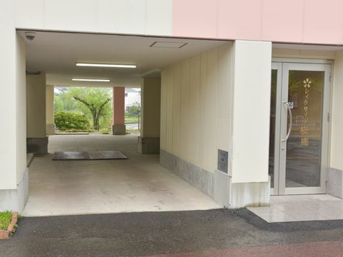 ガラスの開き戸が設置された玄関をもち、玄関脇がピロティになっている建物