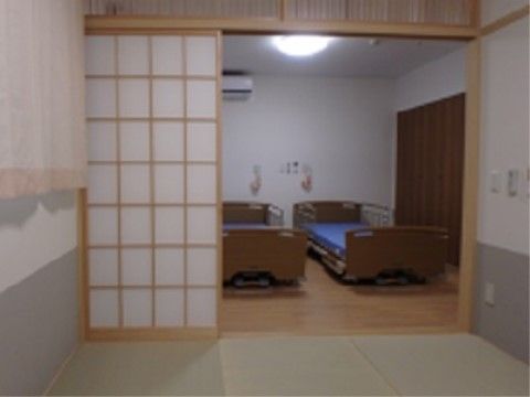 和室と介護用ベッドが置かれた洋室の間が、障子状のふすまで仕切られた部屋