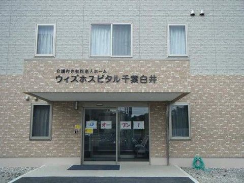 建物の入り口付近。入口は自動ドアでマットが敷いてある。窓は両側に小さいものが1つずつあるだけで、中の様子をあまり伺うことはできない。