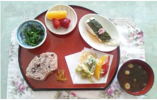 赤飯や味噌汁、天ぷらの盛り合わせやほうれん草のおひたし、オレンジや苺のデザート