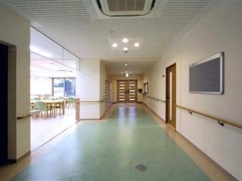 共有スペース前の廊下には、掲示板が貼ってある。廊下の先には、横線が入った２枚の扉があり、隙間から光が入ってきている。