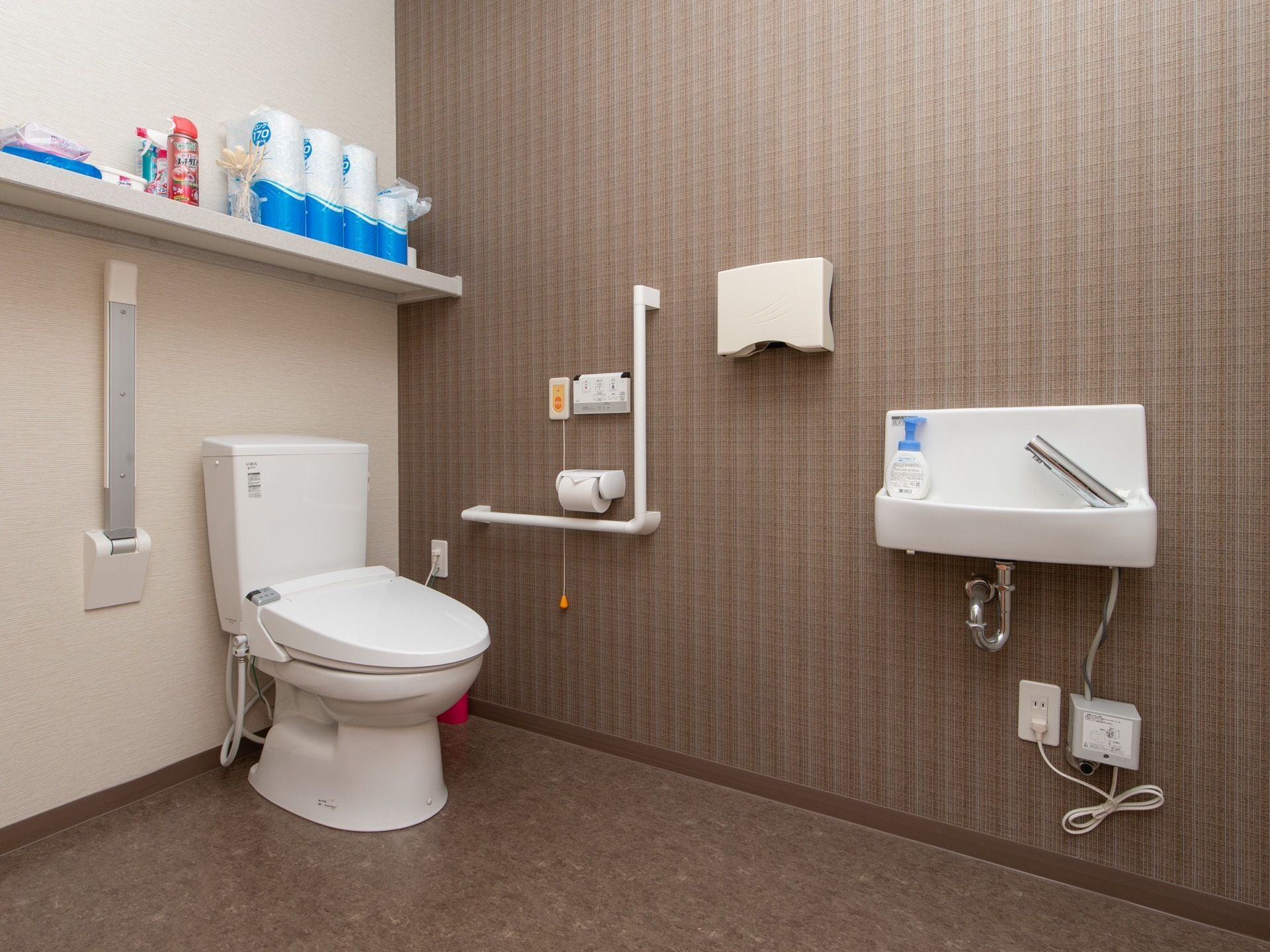トイレに手洗い場が備えつけられており、ハンドソープが用意されている。上部に設置された棚の上には、予備のトイレットペーパーが置かれている。