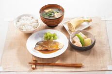 バナナのデザートが付いた、煮魚とごはんと味噌汁のセット