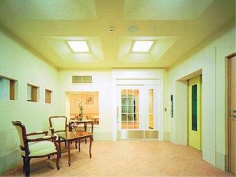 アンティーク調のテーブルと椅子が置かれた、淡い緑色の内装の部屋