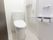 それぞれの居室には個人用の個室トイレが用意されている。緊急時用にオレンジのナースコールが手すりのある壁に取り付けてある。