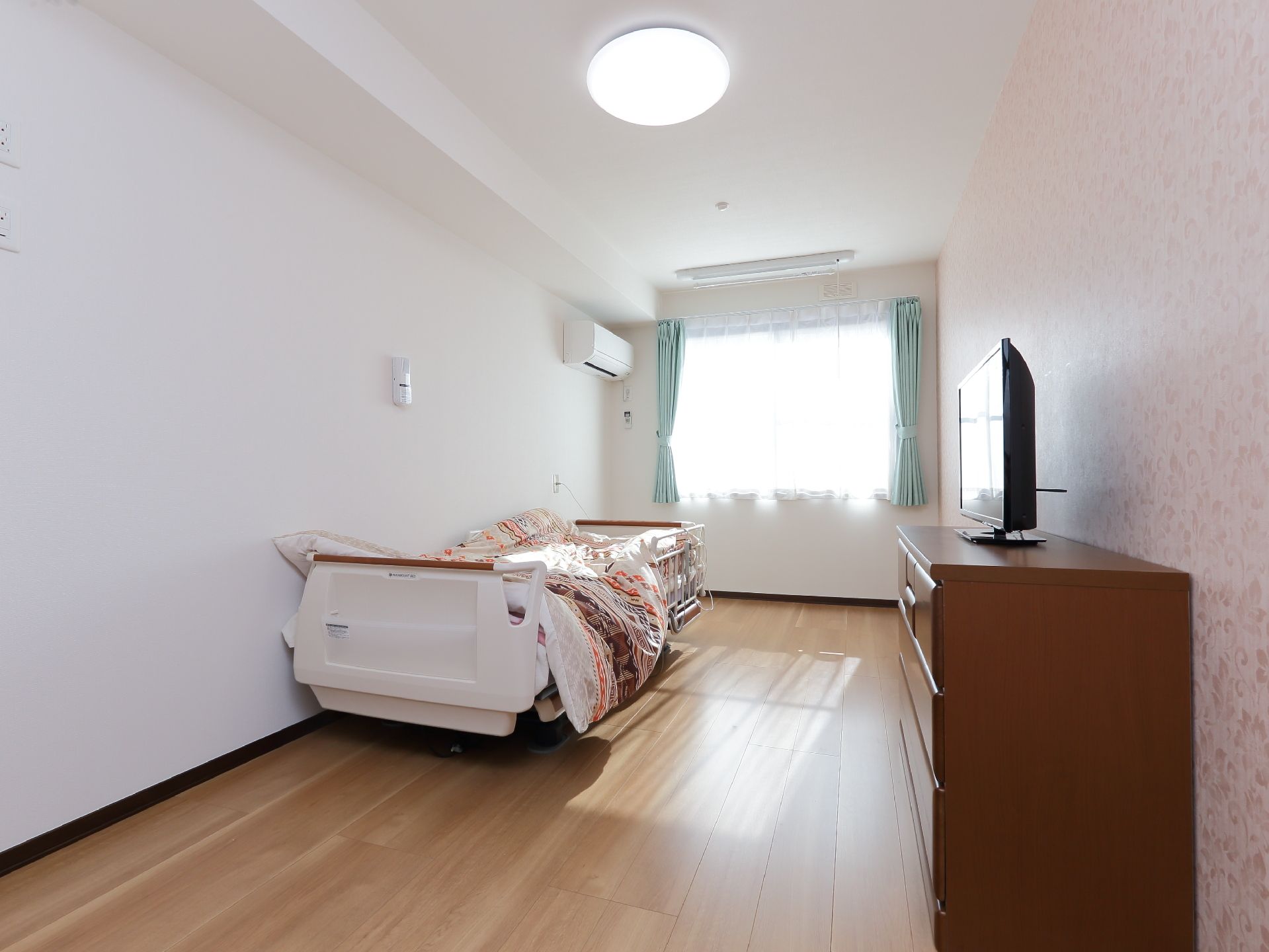 細長い形をしたシンプルな居室。備え付けの設備はベッドなど数種類で、他のテレビやタンスなどの家具は入居者が持ち込む形になる。