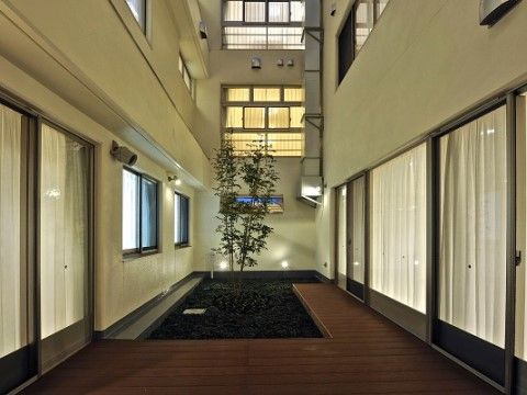 施設内には中庭が作られている。ウッドデッキの一画に植栽がしつらえられており、窓から緑を眺められる造りになっている。
