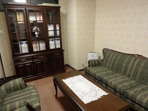 施設内には応接室があり、グレーのソファーが２つと中央にはテーブルが用意されている。部屋の隅には、空気清浄機が置かれている。