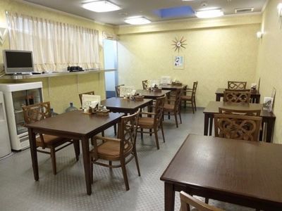 レストランは奥行きがあり、２人掛けのテーブルがたくさん並べられている。左側の棚の上には、テレビが置かれている。