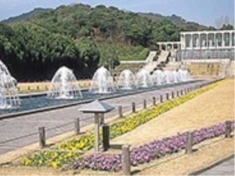 公園には噴水があり美しい。手前の芝には黄色とピンク色のパンジーの花が色分けされて植えられており、統一感がある。