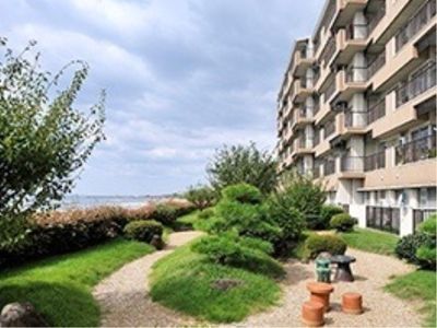 海に面した高台にある建物の前には庭園が設けられている。砂利が敷かれ、緑が豊かな日本庭園風のデザインになっている。
