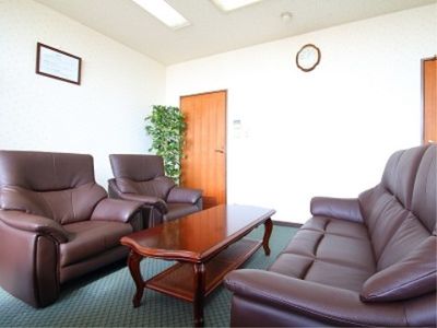 室内にはテーブル、ゆったりとしたソファ、観葉植物が設置されている。壁と天井の色は白色系になっている。