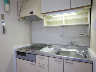 白を基調としたIHコンロ式のキッチンを設けた居室も備えている。上部に換気扇を設置し、収納スペースも充実している。