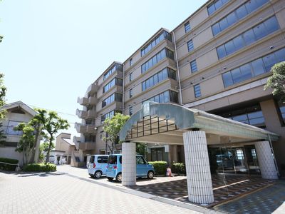 ブラウンの６階建ての建物は、落ち着いた雰囲気である。玄関の前方には４角に大きな柱を設け、上部に大きく縦に長い屋根を設置している。