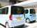 施設名のロゴが窓に描かれた車が2台並んでいる。手前の車は車椅子のまま乗ることができるリフトが設置されている。