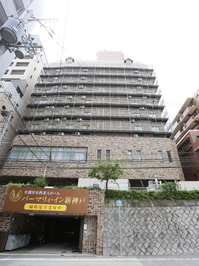 茶色い壁の建物。入口には茶色に金色の文字で書かれた看板が出ている