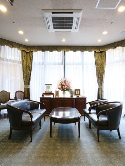天井が高く、ガラス張りの部屋に、高級感あふれる革製の椅子と木製の机が置かれている