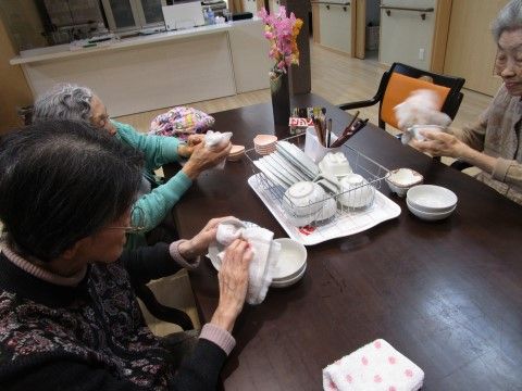 使用した食器類をふきんで拭いている。入居者様同士で協力し合う機会を設けており、仲を深める機会にもなる。