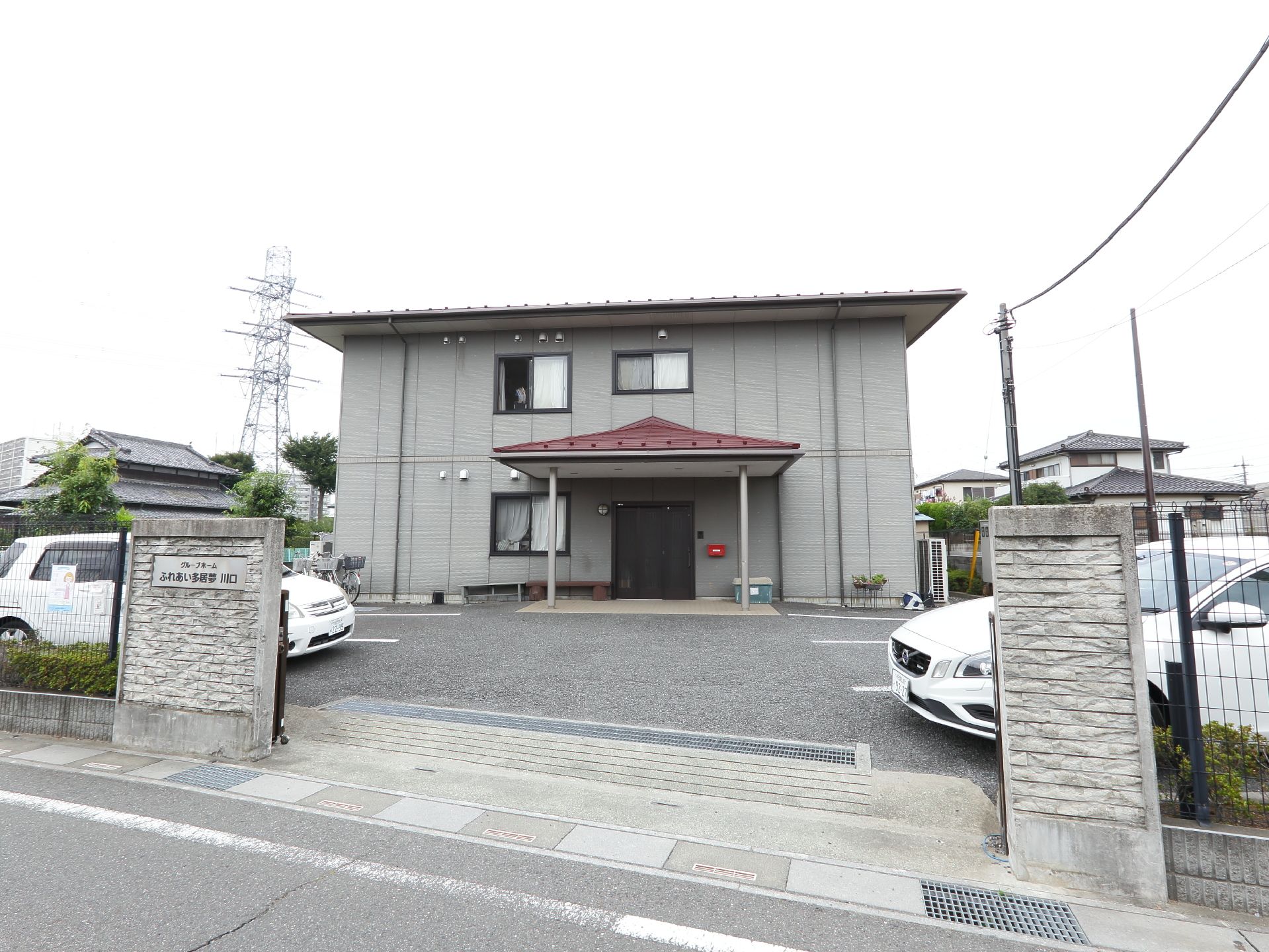 駐車場がたくさんある。入口の前には屋根がついている。グレーで統一された建物で落ち着いた雰囲気である。