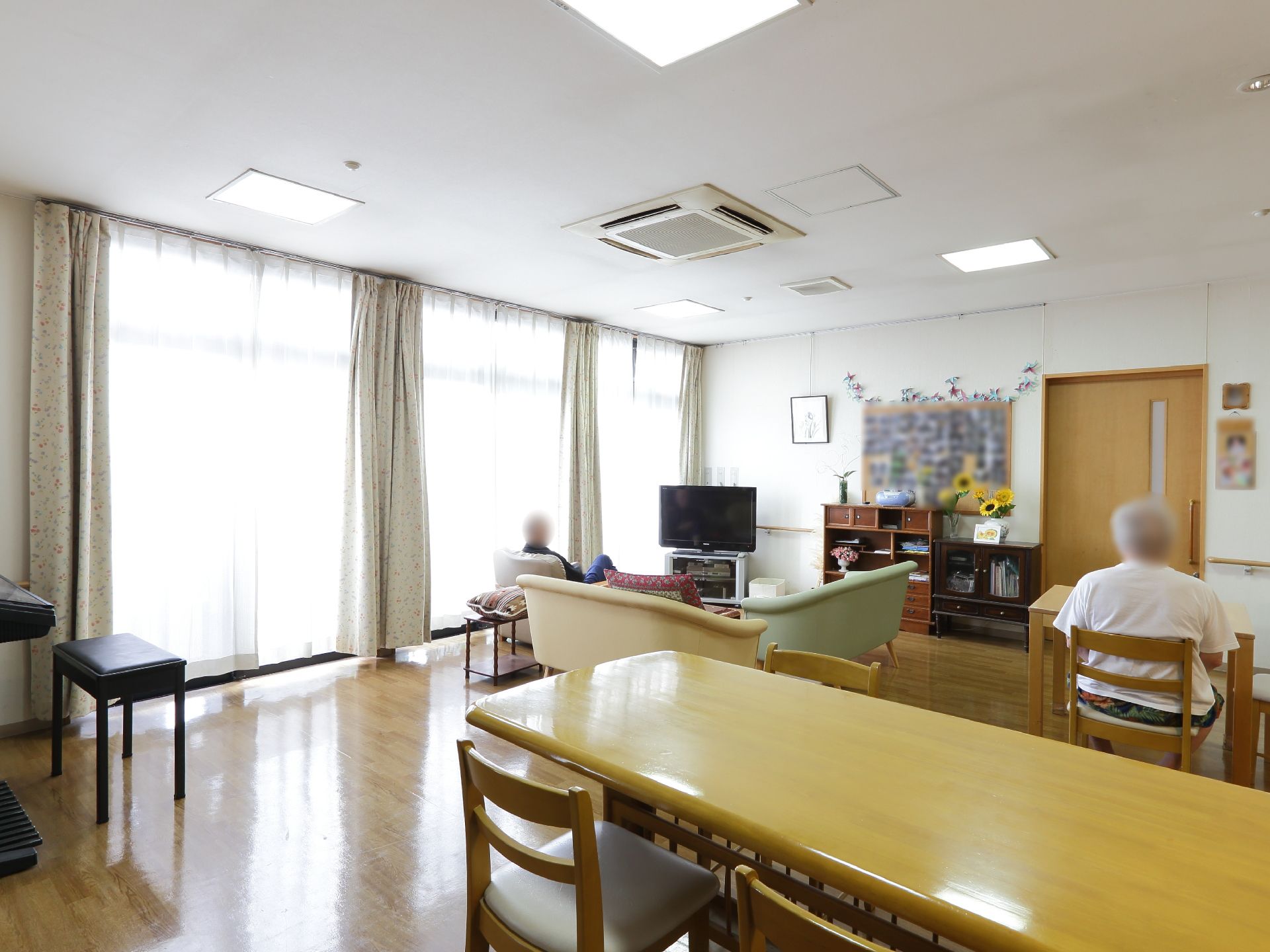 入居者が自由に利用できる共用スペース。テレビの前にはソファーが置かれ、その反対側にはピアノのような楽器がある。