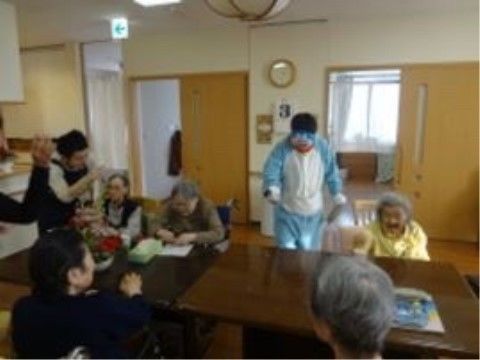 木調のテーブルがあるリビングに集い、思い思いに話をする入居者の皆様