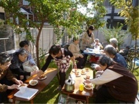 敷地内に生えている木々の下に集まっている入居者様たち