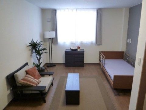 部屋の中央に細長いローテーブルがあり、その近くの壁際にソファが置かれている居室
