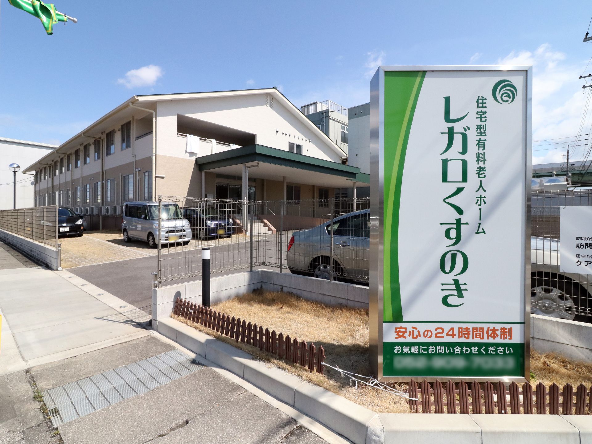 落ち着いた色合いの建物。爽やかな緑の看板がある。