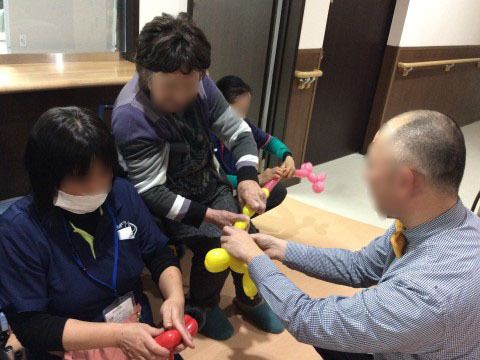「住宅型有料老人ホームレガロくすのき」のイベント。バルーンアートの実演を行っている。