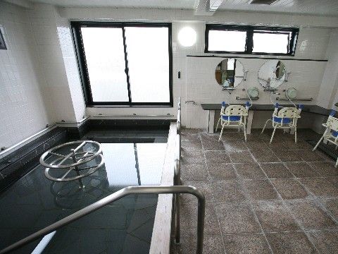 明るい浴室の洗い場には大判で丸い形のお洒落な鏡が設置されており、入居者様は体を洗う際に気軽に使用できる。