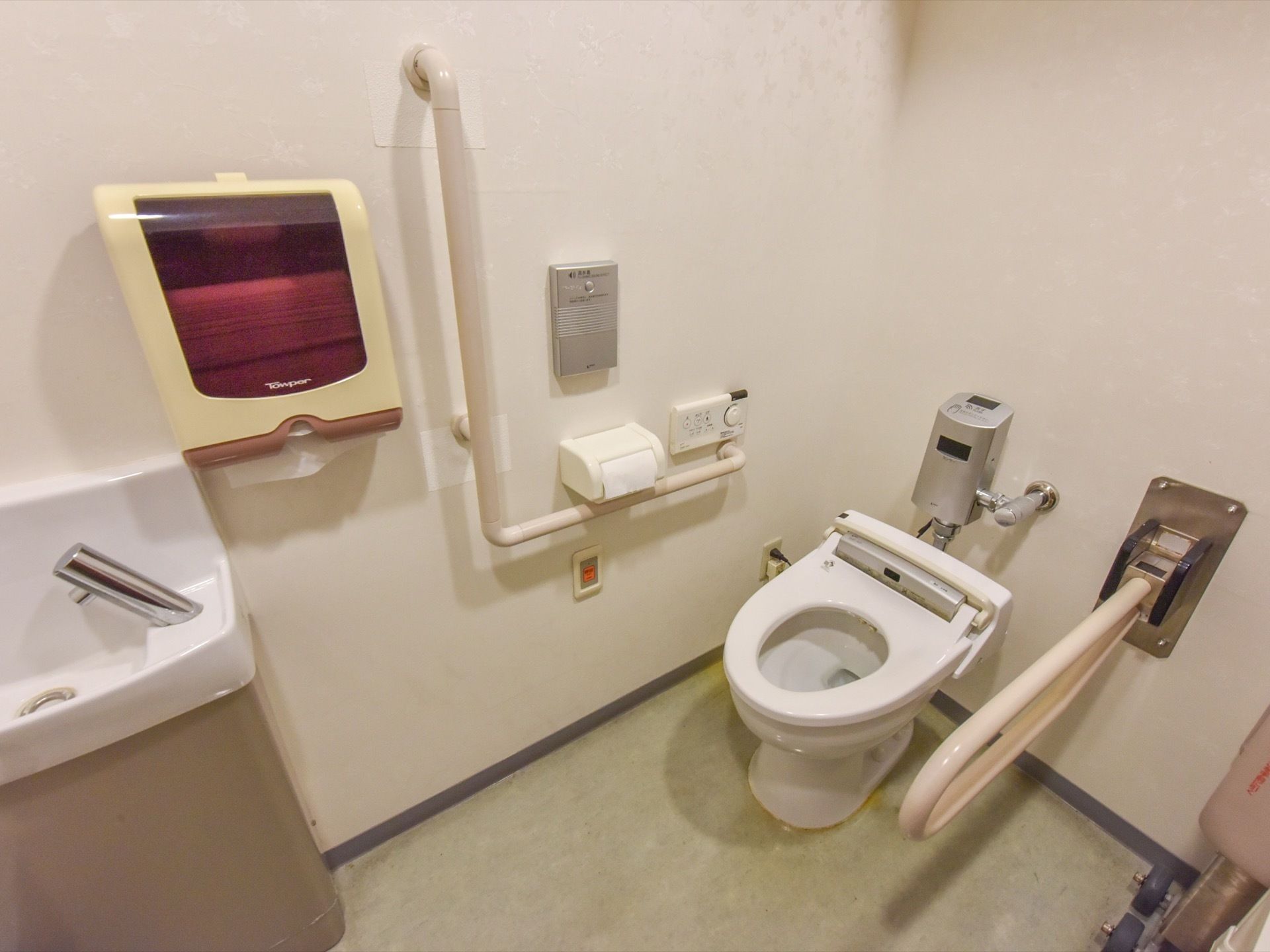 トイレは蓋の無いタイプとなっており、便座の両サイドには手すりがつけられている。後ろ側には手をかざして水を流す機械がつけられている。