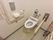 トイレは温水洗浄便座となっており、壁際には専用のボタンやトイレットペーパー、手すりが設置されている。