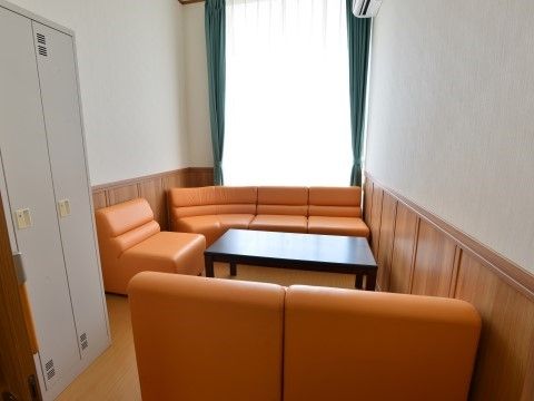 濃い緑色のカーテンとオレンジのソファーが、美しい配色をなす小部屋がある。談笑するのにぴったりの場所である。
