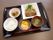黒いお盆の上にご飯、果物、副菜、メインディッシュ、汁物が置いてある。それぞれ器が違うため、味移りの心配がない。