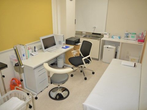 壁際に診察用ベッド、机の上にパソコンのモニターが置かれている医務室