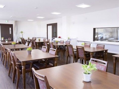 リビングの壁にはキッチンの風景が見えるように、小窓が設置されている。壁には手すりが取り付けられている。