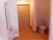 大きな木目調のドアの近くに、トイレと洗面台が設置されている。トイレの中には手すりが付いており、カーテンで仕切るようになっている。