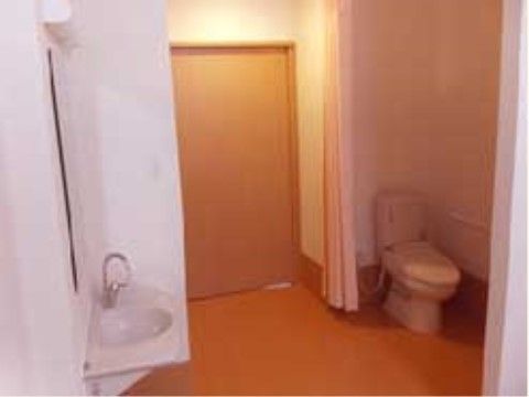 トイレの入り口は広くなっており、カーテンが取り付けられている。段差がないので、車椅子をご利用の方でも移動が楽に行える。