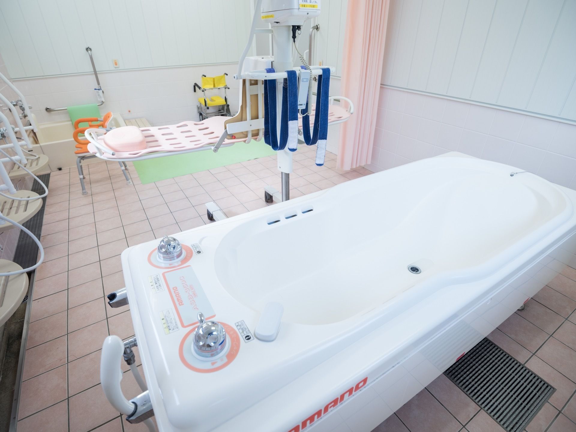 洗い場が数カ所設けられた広い浴室がある。手前にはストレッチャーの付いた大きな機械浴槽がある。