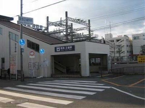 横断歩道の向こう側にある、駅名が表示された階段上り口