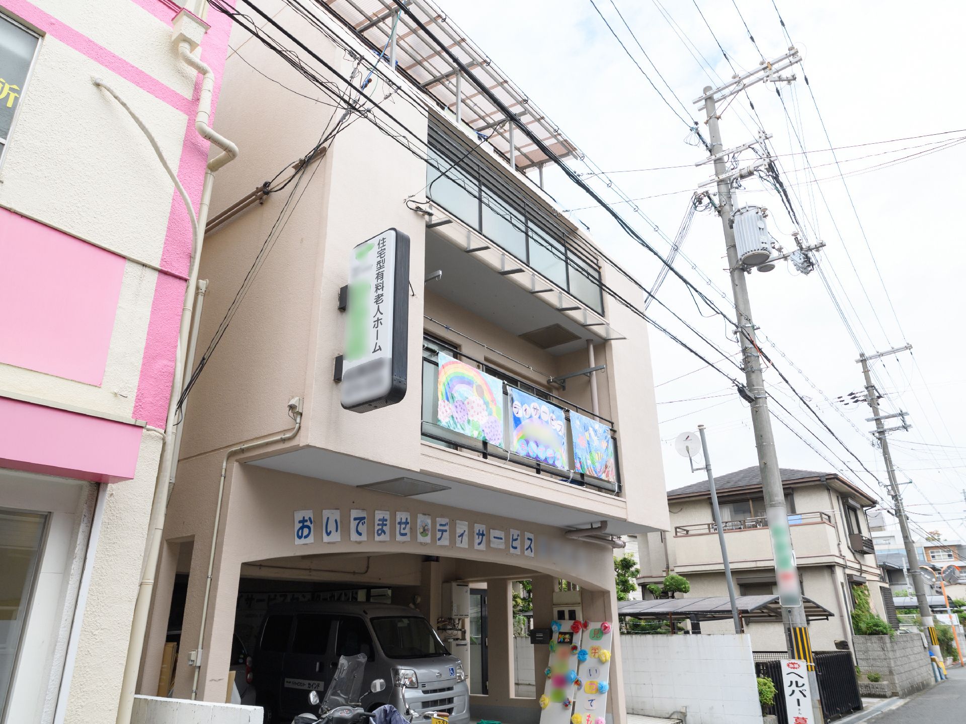 施設の前は道路になっており、近くの電柱には、施設名の表示があり、通りを歩く人や車で通る人にもわかりやすくなっている。