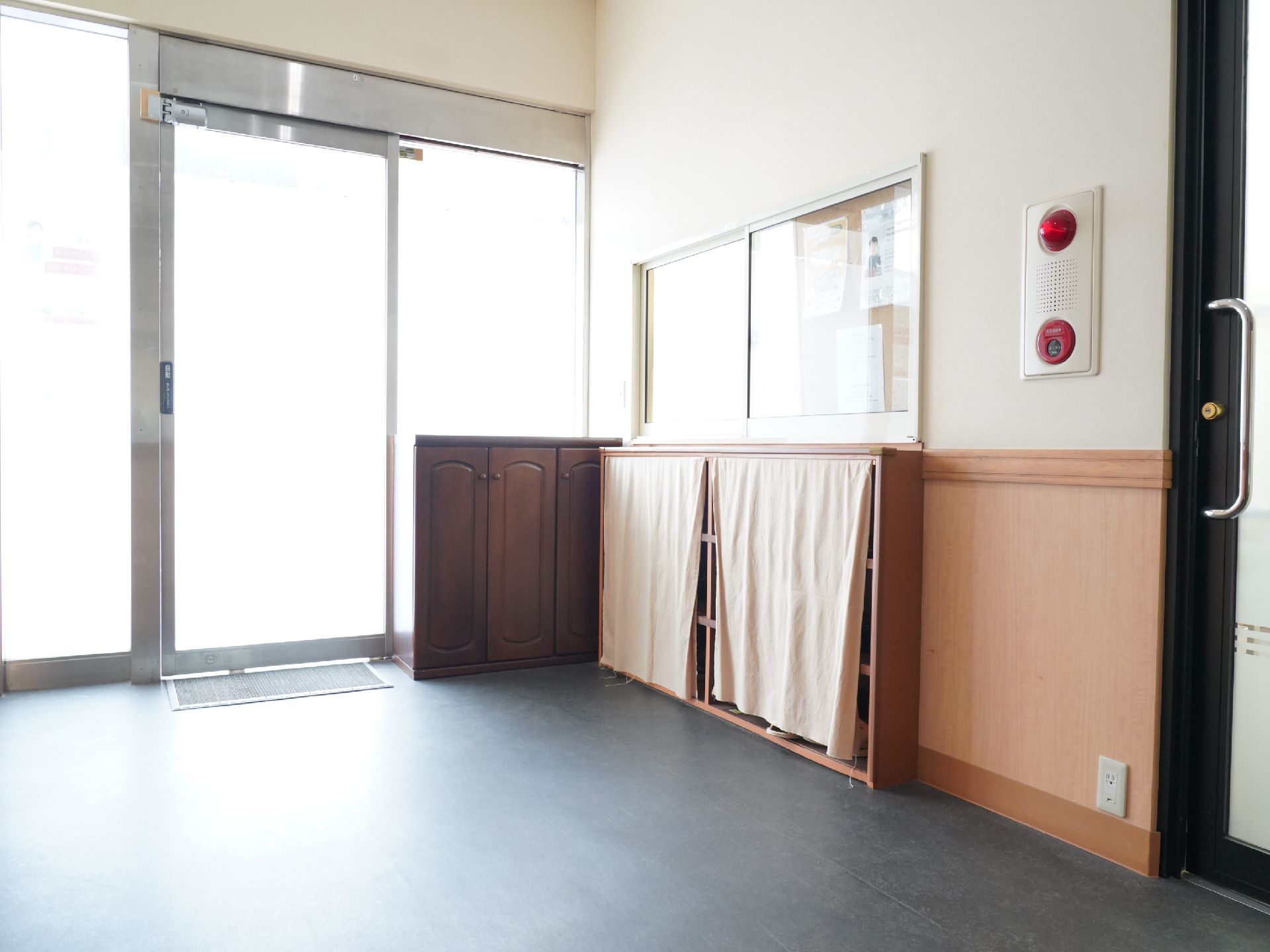 大きな布で目隠しがされている靴棚のすぐ上にある受付窓口
