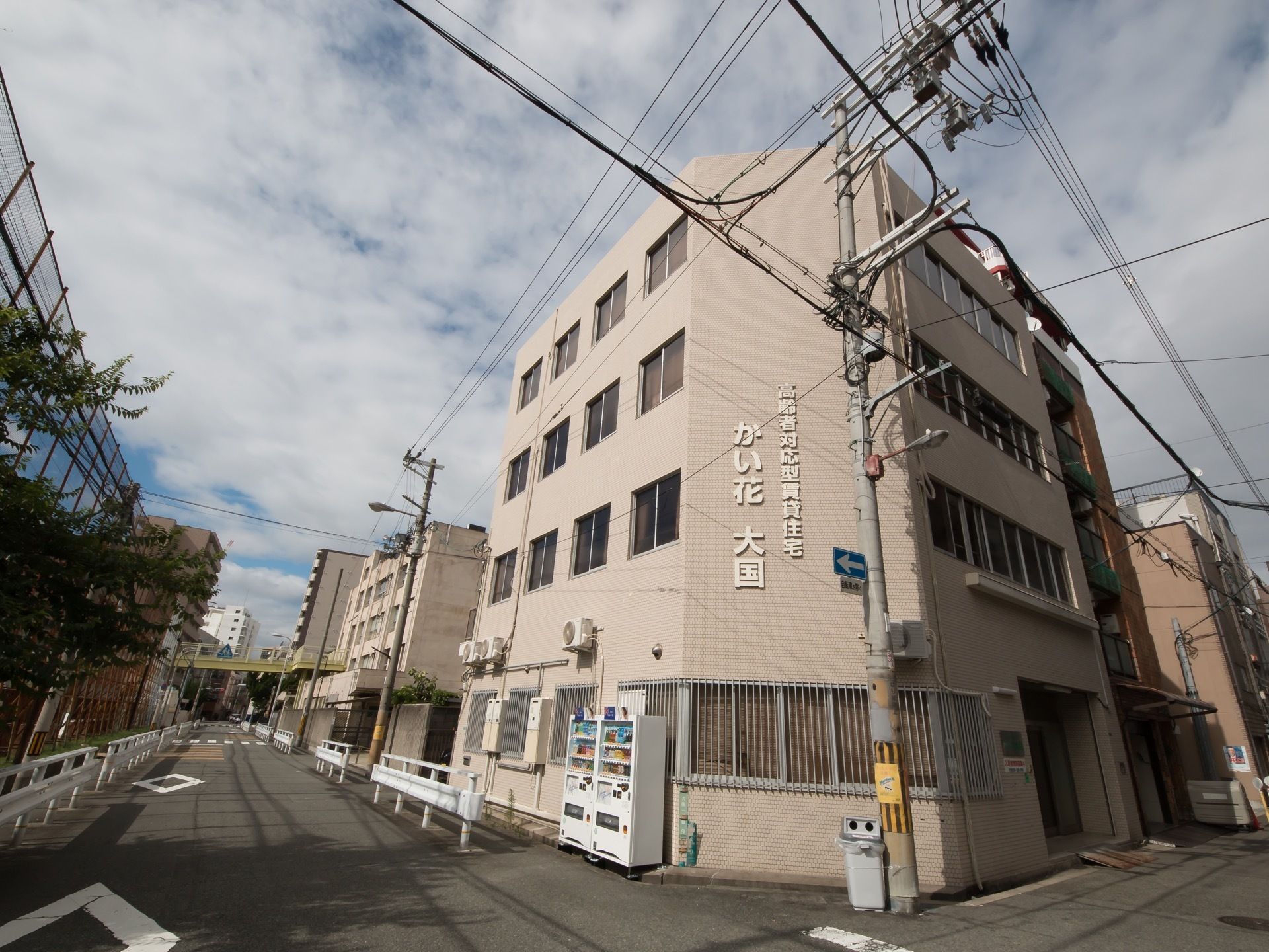 鉄筋４階建て全18室のピンク色の建物で自動販売機が２台置かれている。周囲には大きな病院や小学校、住宅などがある。
