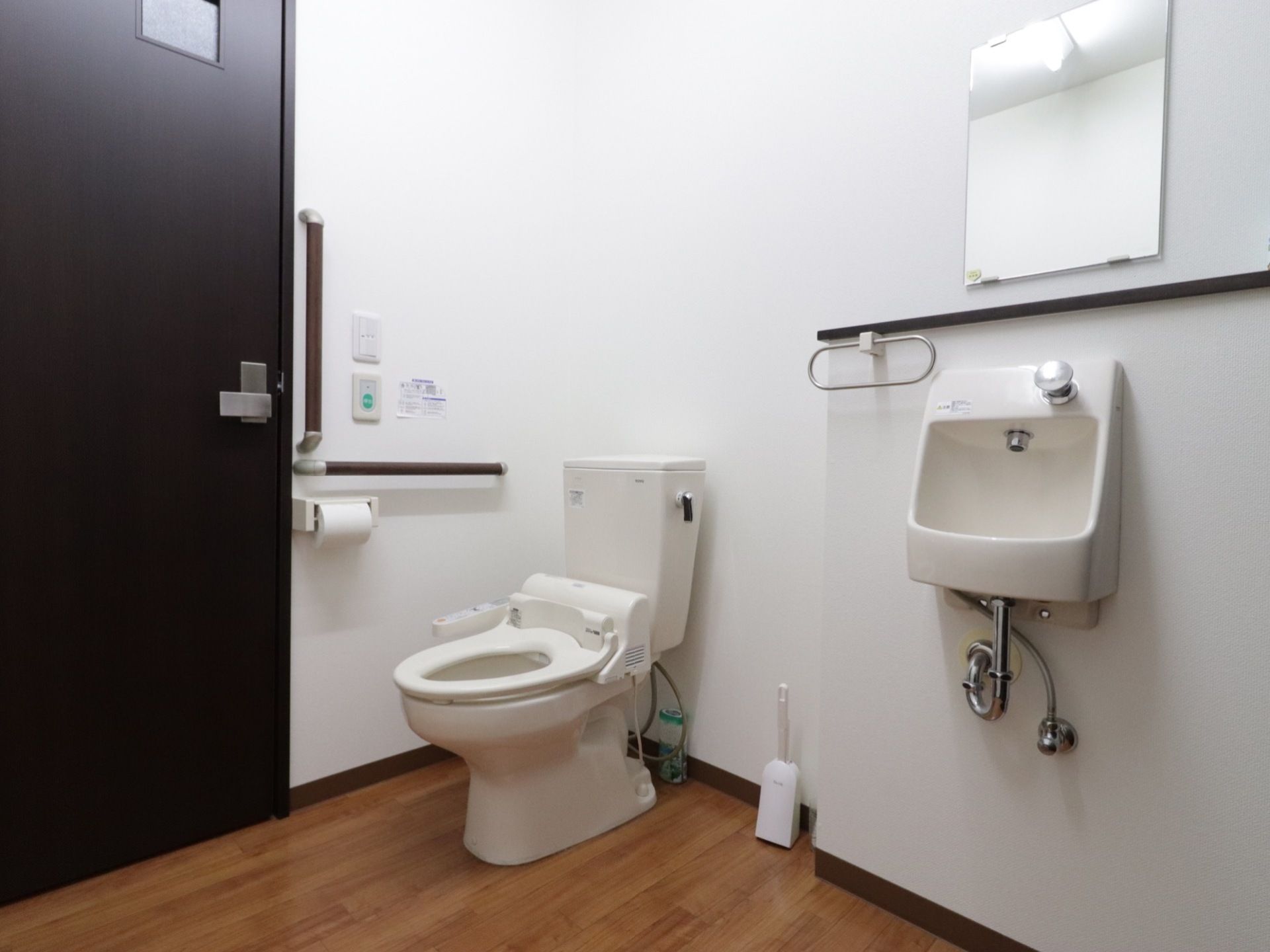 手すりが完備された広いトイレがある。便座は温水洗浄機能付きで、手洗い場や鏡も同じ空間内に設置されている。