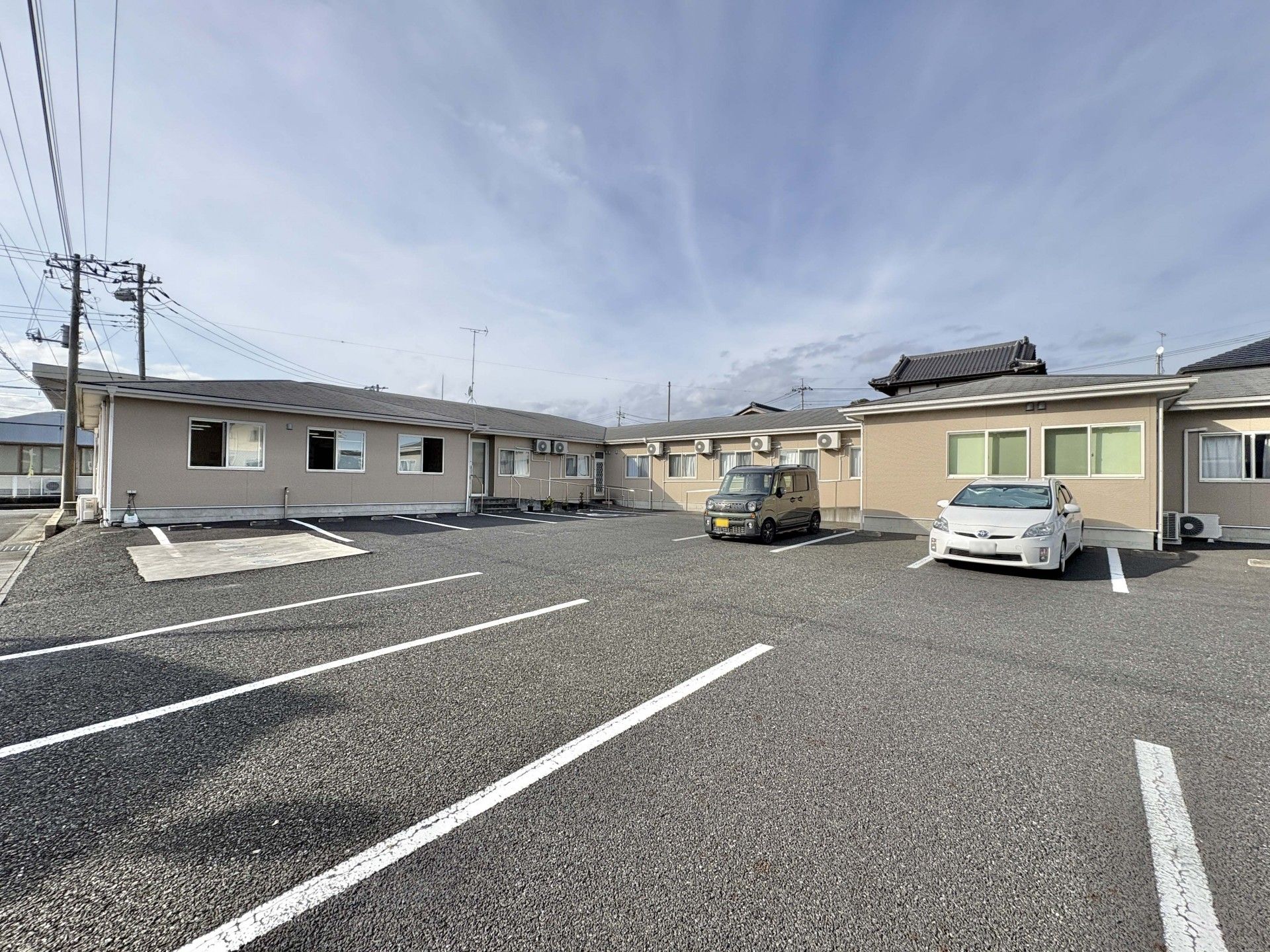 広々とした駐車場の施設外観