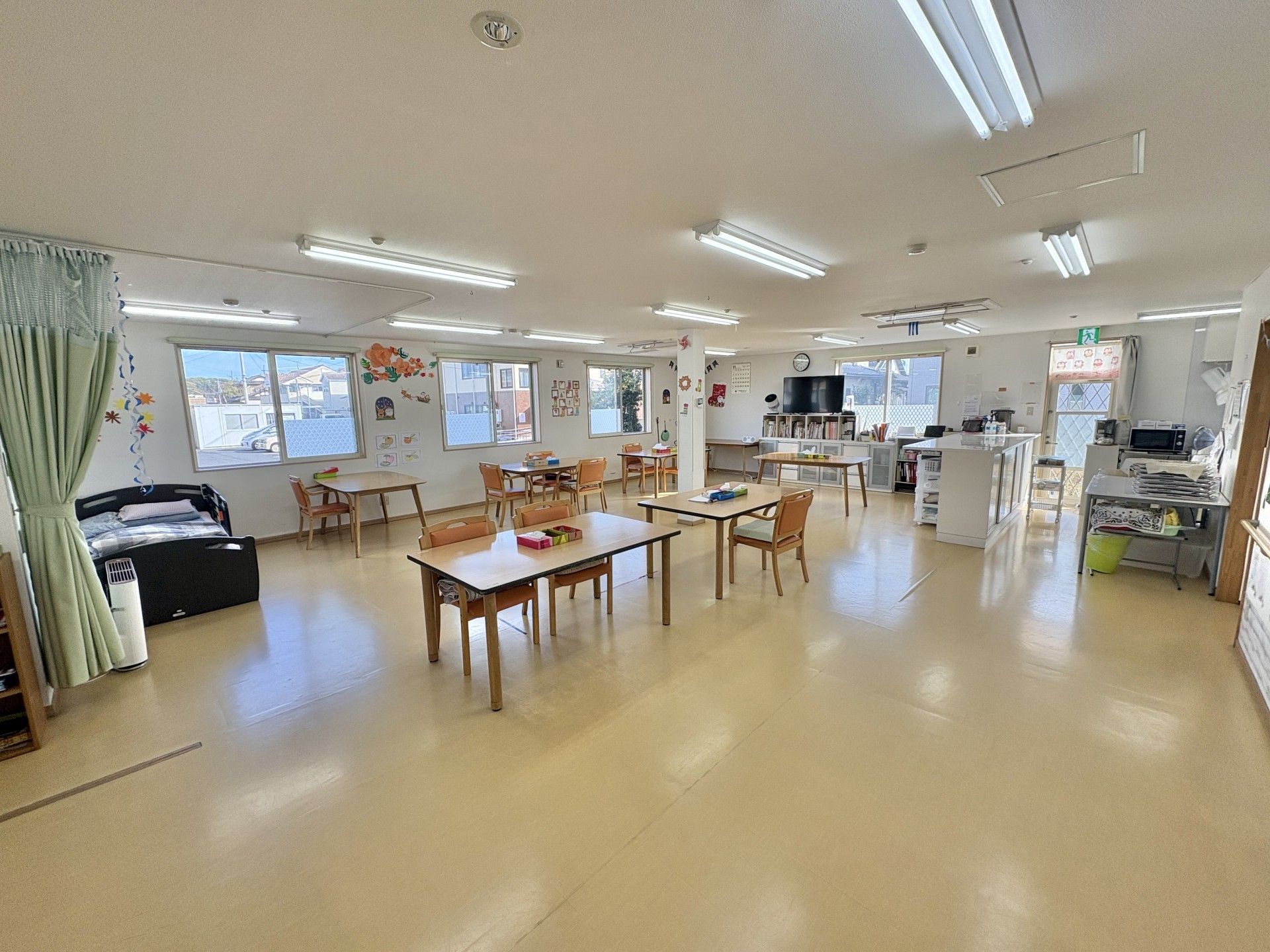 車椅子に乗った高齢女性と目線を合わせる女性ヘルパー